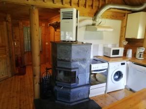 a kitchen with a fireplace and a microwave and a stove at Cottage-karaoke Koivikko in Äänekoski