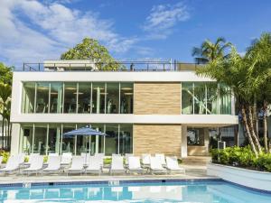 a house with a swimming pool and white chairs at Fairmont El San Juan Hotel in San Juan
