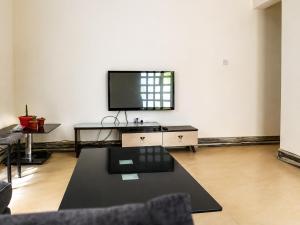 a living room with a flat screen tv on a wall at Jules Place Arusha in Themi