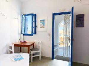 a room with a table and a table and a door at Villa Solasta #2 with jacuzzi in Santorini in Akrotiri