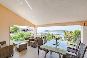 a living room with a table and chairs and a large window at Villa Milina Korčula in Vela Luka