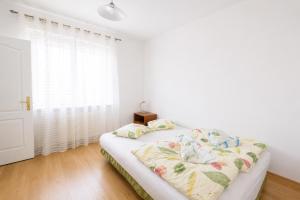 a white bedroom with a bed and a window at Extra Apartamenty - Apartament przy plaży in Sopot +2 photos