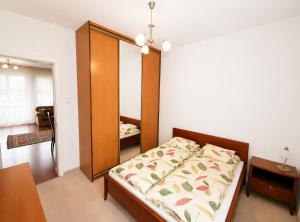 a bedroom with a bed with a wooden headboard at Extra Apartamenty - Apartament przy plaży in Sopot