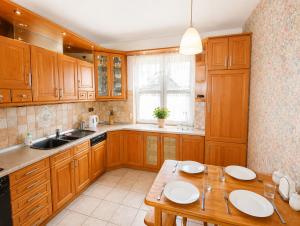 a kitchen with wooden cabinets and a wooden table at Extra Apartamenty - Apartament przy plaży in Sopot