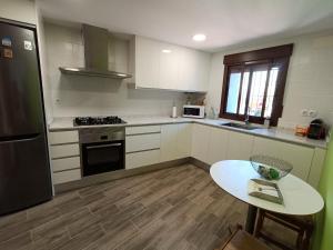 a kitchen with white cabinets and a table in it at Casa Remedios in Cubla
