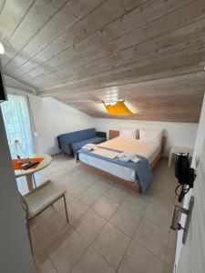 ein Schlafzimmer mit einem Bett, einer Couch und einem Tisch in der Unterkunft Orange House in Keramotí