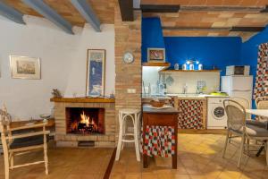 a kitchen with a fireplace and a table and chairs at Casa Blava in Orriols