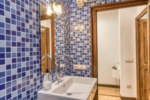 a blue tiled bathroom with a sink and a mirror at Casa Blava in Orriols +23 photos