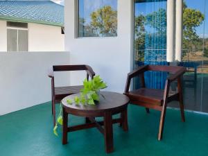 two chairs and a table with a plant on a porch at Bundala Forest Resort Yala in Weerawila