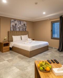 a bedroom with a bed and a table with fruit on it at فندق جراند السالمية Salmiya Grand Hotel in Kuwait +103 photos