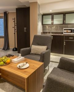 a living room with a table and chairs and a kitchen at فندق جراند السالمية Salmiya Grand Hotel in Kuwait