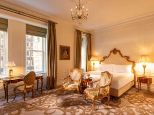 a bedroom with a bed and a table and chairs at The Plaza, A Fairmont Hotel in New York +165 photos