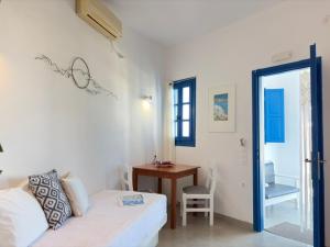 a bedroom with a bed and a table and a desk at Villa Solasta #2 with jacuzzi in Santorini in Akrotiri