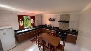 a kitchen with a wooden table and chairs in it at Casa Ferrari in Santa Teresa