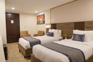 a hotel room with two beds and a table at RT Serene Hotel - Hyderabad in Hyderabad