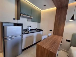 a kitchen with a refrigerator and a wooden table at Résidence Hotelière Fleurie in Agadir