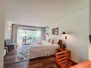 a bedroom with a bed and a living room at La Bonita Suites Punta Colorada in Punta Colorada