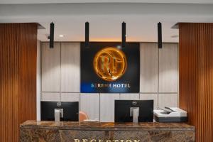 a hotel lobby with a gold sign on the wall at RT Serene Hotel - Hyderabad in Hyderabad