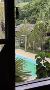 a view of a swimming pool from a window at Casa Ferrari in Santa Teresa