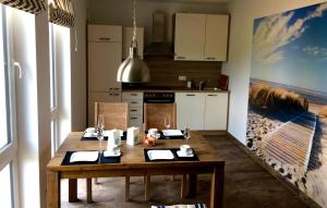 a kitchen with a wooden table in a room at Ferienwohnung Achterbrise mit Kamin in Zinnowitz