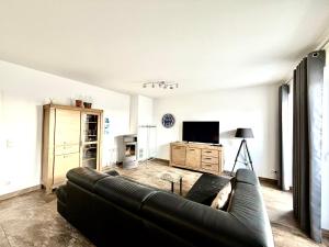 a living room with a couch and a tv at Ferienwohnung Achterbrise mit Kamin in Zinnowitz