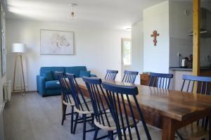 a dining room with a table and chairs and a blue couch at Notre Dame Du Laus in Saint-Étienne-le-Laus