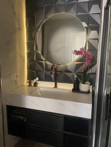 a bathroom with a sink with a mirror and flowers at Burgos Spa and Cathedral in Burgos