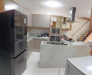 a kitchen with a black refrigerator and a counter at Suite Vila dos Cabanos Barcarena in Barcarena