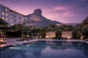 a hotel with a pool with a mountain in the background at Hillcrest Hotel & Resort, Abu Road in Ābu Road