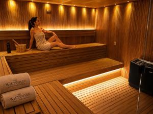 a woman is sitting in a sauna at The Wiltshire Hotel, Golf and Leisure Resort in Swindon