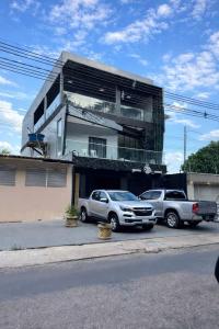 two cars parked in front of a building at Suite Vila dos Cabanos Barcarena in Barcarena