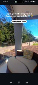a room with a couch and a view of a beach at Suite Vila dos Cabanos Barcarena in Barcarena