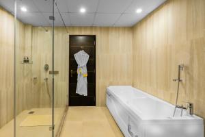a bathroom with a bath tub and a glass shower at Span inn & Suites by Alivaa, Manali in Baragrān