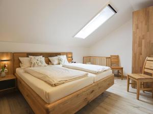 a bedroom with a large bed with a skylight at Mojer-Hof in Taching am See