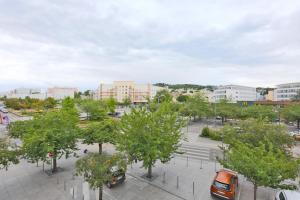 a city with cars parked in a parking lot with trees at KOSY Appart'Hôtels - La Maison Des Chercheurs in Vandoeuvre-lès-Nancy