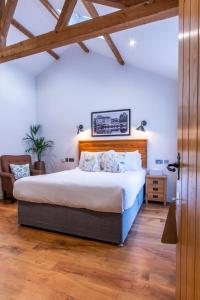 a bedroom with a large bed with a wooden headboard at The Chequers at Burcot in Oxford