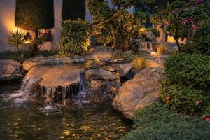 a waterfall in a garden with rocks and plants at Hillcrest Hotel & Resort, Abu Road in Ābu Road +40 photos
