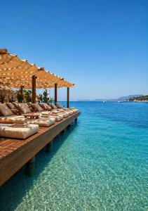 a row of lounge chairs on a pier in the water at Mare Deluxe Residences & Villas in Bodrum City