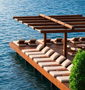 a wooden dock with chairs on the water at Mare Deluxe Residences & Villas in Bodrum City