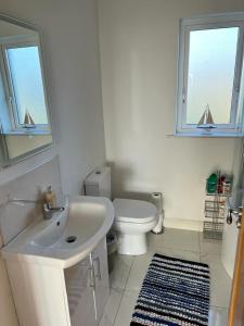 a white bathroom with a sink and a toilet at Beach House in Donegal