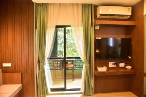 a room with a window with a television and a desk at UnigoOne Apartments, BH, Palolem in Canacona