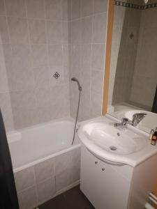 a bathroom with a sink and a bath tub next to a white sink at KOSY Appart'Hôtels - La Maison Des Chercheurs in Vandoeuvre-lès-Nancy +34 photos