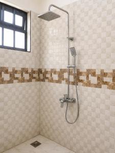 a shower in a tiled bathroom with at Jules Place Arusha in Themi