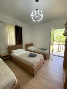 a bedroom with two beds and a chandelier at Guesthouse Natyra Theth in Theth
