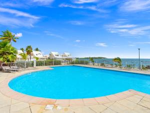 a swimming pool with the ocean in the background at Shell Beach - Magnifique Loft sur la plage in Baie Nettle