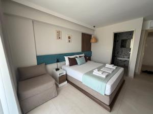 a bedroom with a large bed and a couch at Elegant Corner Superior Rooms & Apartments in Limenaria
