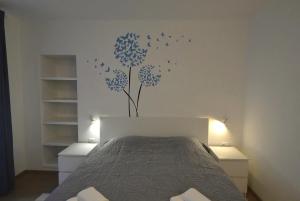 a bedroom with a bed with blue flowers on the wall at Apartments and Rooms Oliva in Cres
