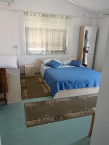 a bedroom with a bed with blue sheets and a window at Apartments Marica in Trogir