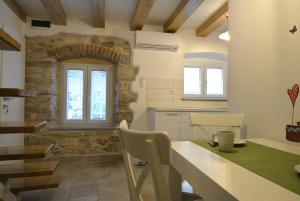 a kitchen with a table and a stone wall at Apartments and Rooms Oliva in Cres