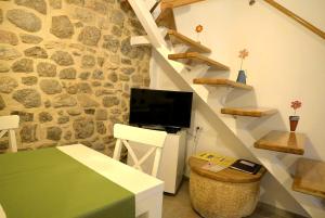 a room with a staircase with a tv and a table at Apartments and Rooms Oliva in Cres